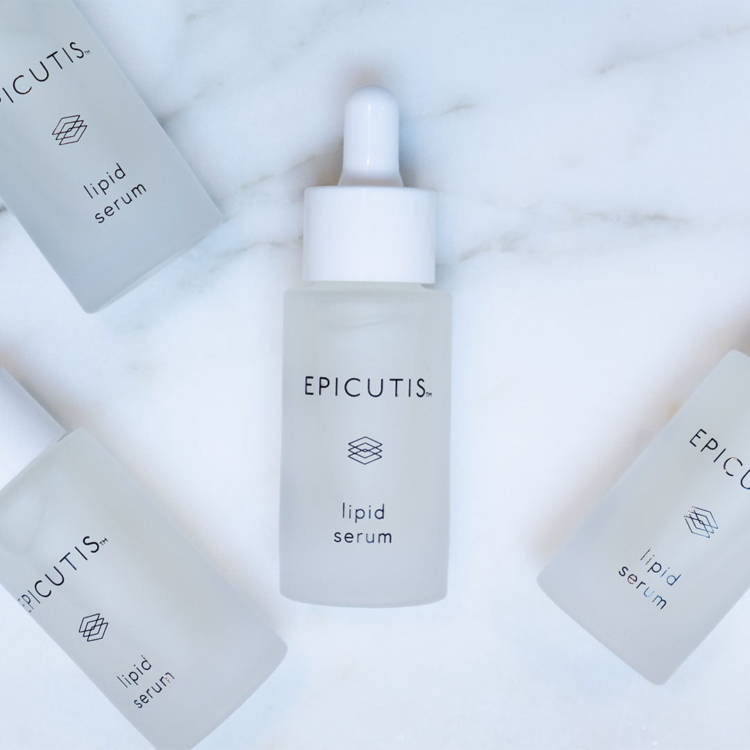 EPICUTIS Lipid Serum in a frosted glass dropper bottle, surrounded by three flat bottles, on marble.