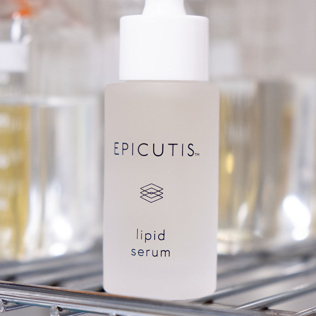 EPICUTIS Lipid Serum in a frosted glass bottle with a white dropper cap, on a metal rack.