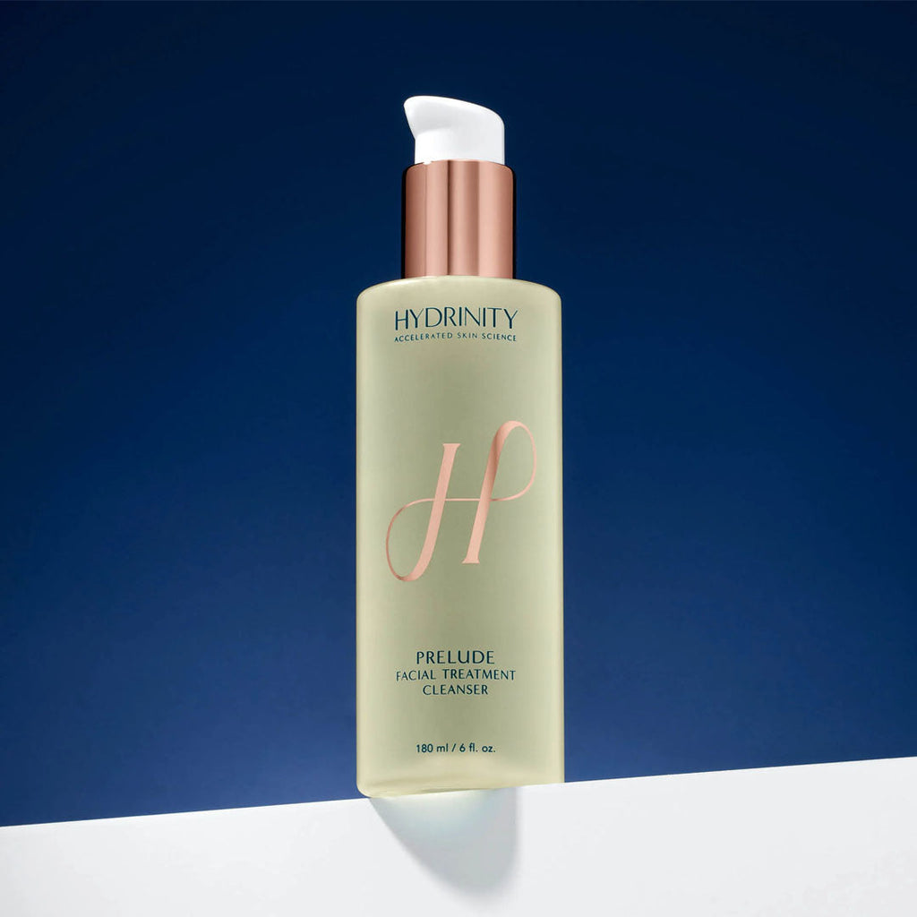 Hydrinity Prelude Facial Treatment Cleanser, a tall, pale green bottle with a rose gold pump and "H" logo.