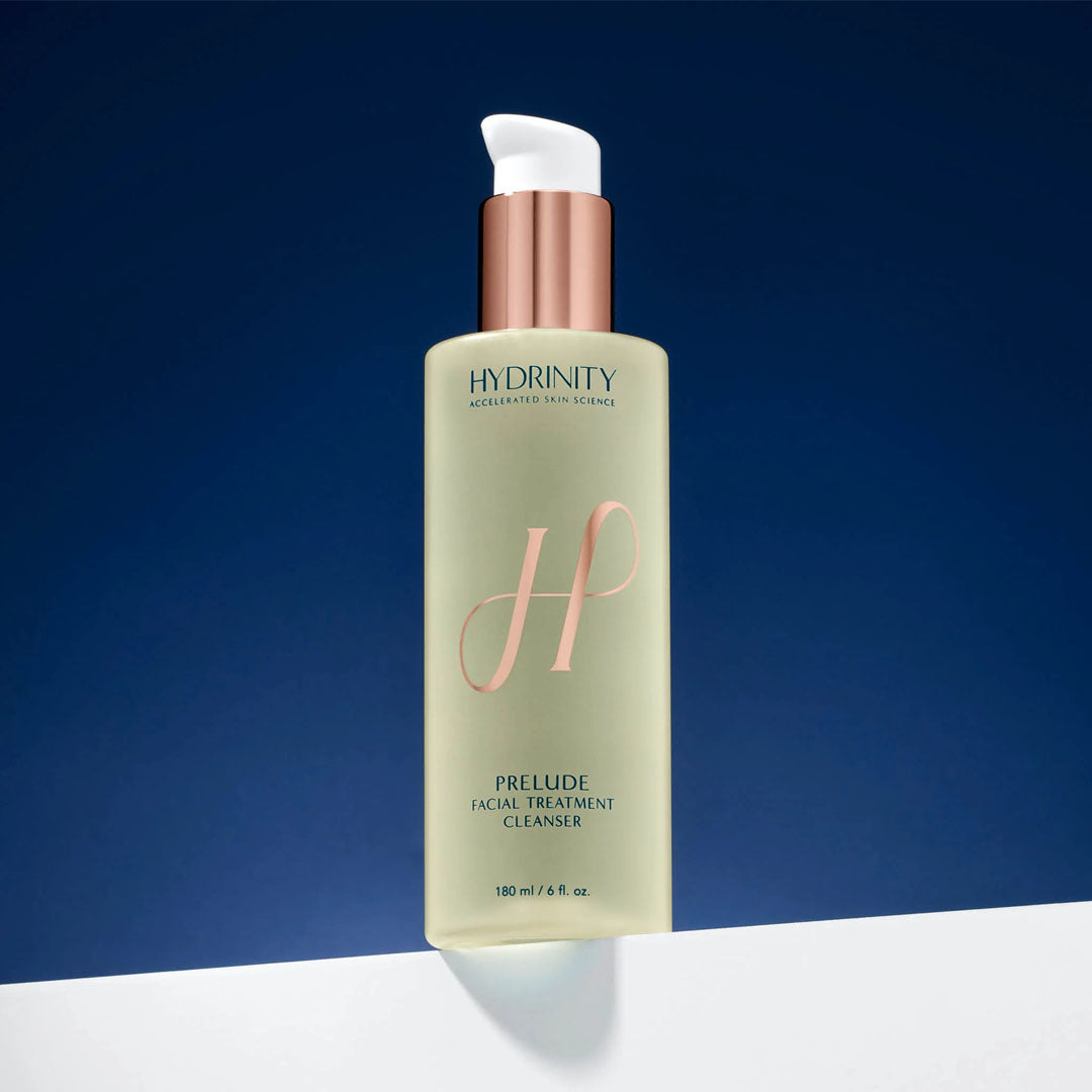 Hydrinity Prelude Facial Treatment Cleanser, a tall, pale green bottle with a rose gold pump and "H" logo.