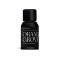 Small dark amber glass bottle of Vitruvi Orange Grove essential oil blend with a black cap.