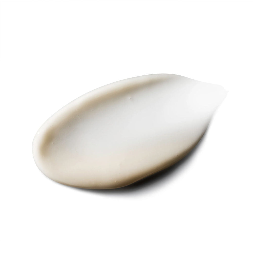 A creamy, off-white swatch of Vivid Brightening Serum with a smooth texture on a white background.