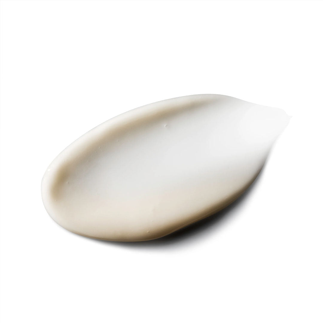A creamy, off-white swatch of Vivid Brightening Serum with a smooth texture on a white background.